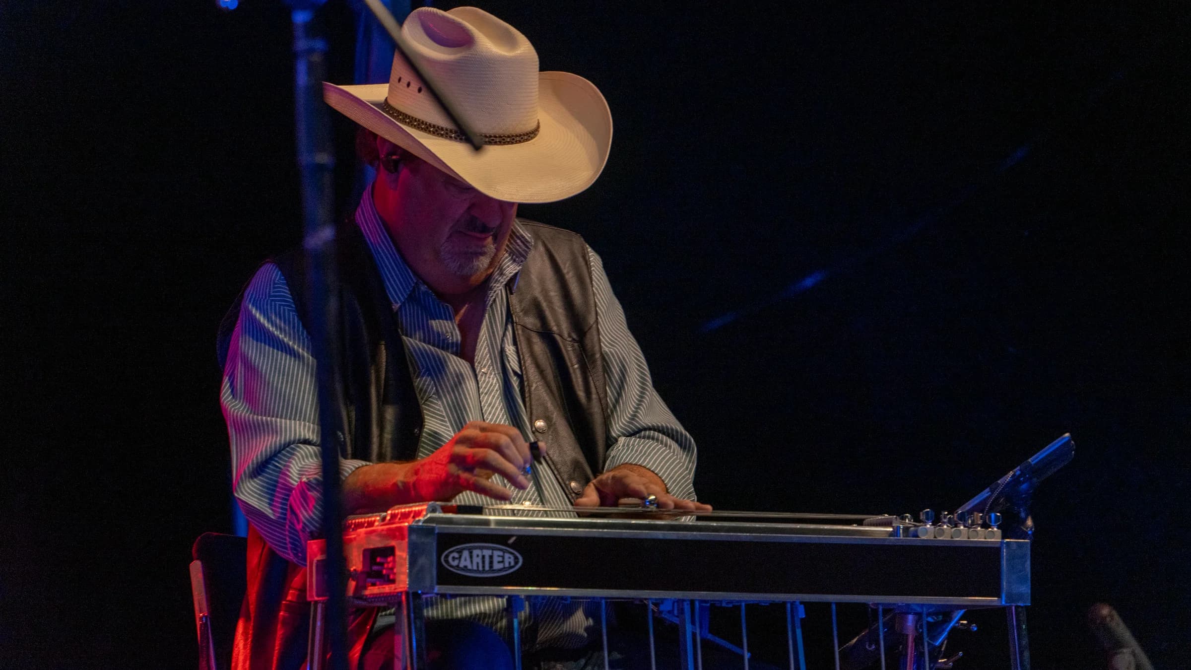 Steel guitarist in a cowboy hat during a live performance